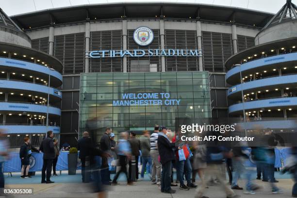 Supporters gather outside the stadium before the English Premier League football match between Manchester City and Everton at the Etihad Stadium in...