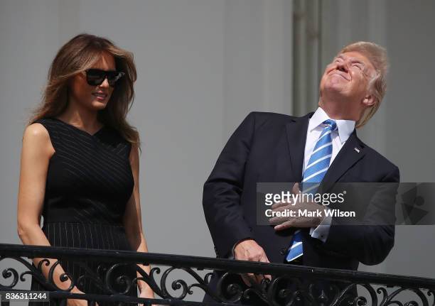 President Donald Trump looks up toward the Solar Eclipse while joined by his wife first lady Melania Trump on the Truman Balcony at the White House...