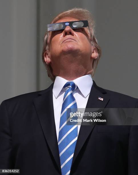 President Donald Trump wears special glasses as he looks up toward the Solar Eclipse on the Truman Balcony at the White House on August 21, 2017 in...