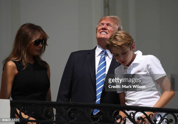 President Donald Trump looks up toward the Solar Eclipse while standing with his wife first lady Melania Trump and their son Barron, on the Truman...