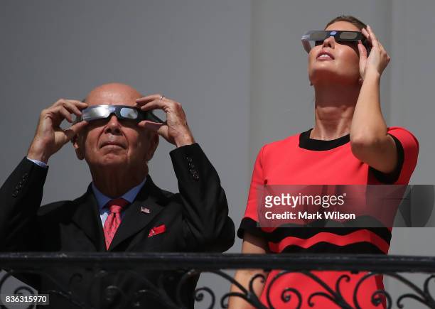Ivanka Trump and Commerce Secretary Wilbur Ross wear special glasses to look up at the Solar Eclipse, at the White House on August 21, 2017 in...