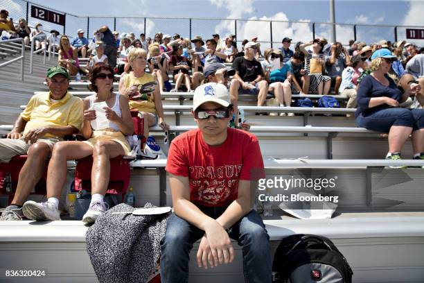 Man wears solar viewing glasses while sitting in the stands during a solar eclipse viewing event on the campus of Southern Illinois University in...