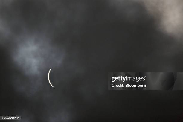 Sliver of the sun remains visible through a passing cloud during a solar eclipse as seen from a viewing event on the campus of Southern Illinois...