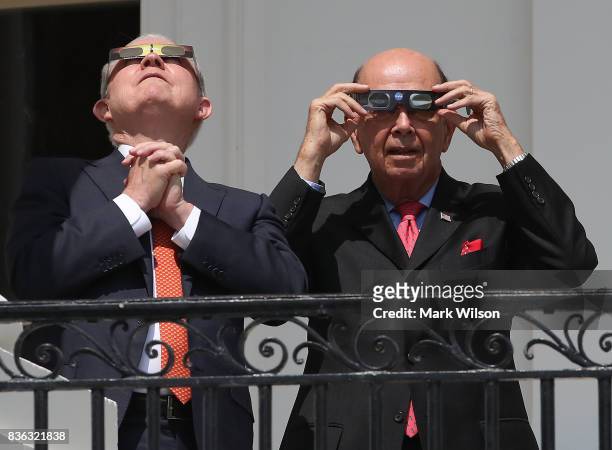 Attorney General Jeff Sessions and Commerce Secretary Wilbur Ross wear special glasses to view the solar eclipse at the White House on August 21,...