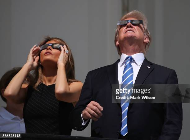 President Donald Trump and his wife first lady Melania Trump wear special glasses to view the solar eclipse at the White House on August 21, 2017 in...