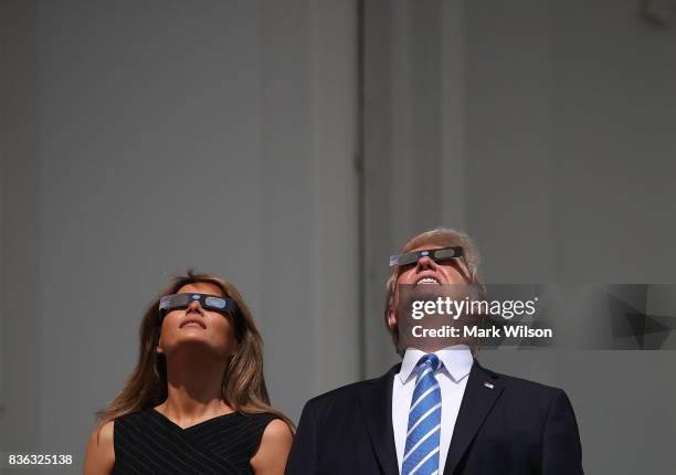 President Donald Trump and his wife first lady Melania Trump wear special glasses to view the solar eclipse at the White House on August 21, 2017 in...