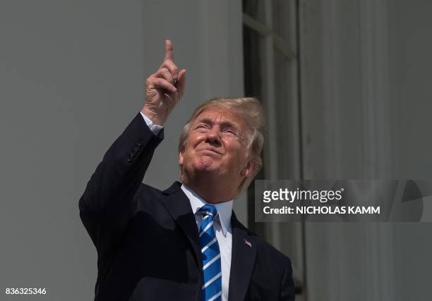 President Donald Trump looks up at the partial solar eclipse from the balcony of the White House in Washington, DC, on August 21, 2017.