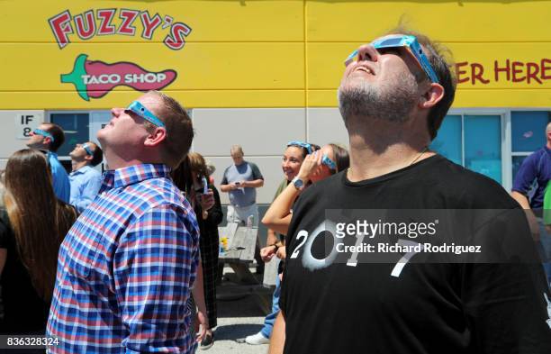 Texas Motor Speedway President Eddie Gossage and other TMS staff use eclipse glasses to watch the solar eclipse at a party at Fuzzy's Tacos at Texas...