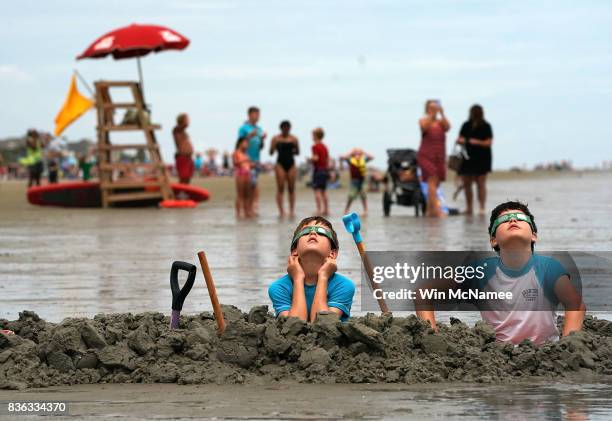 Brothers Chris and Gabe Fabiano watch the first solar eclipse to sweep across the United States in over 99 years on the beach August 21, 2017 on...