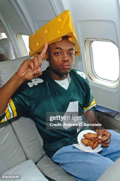 Nick Van Exel of the Los Angeles Lakers wears a cheesehead and Brett Favre jersey on the plane on October 18, 1996 in Inglewood, California. NOTE TO...