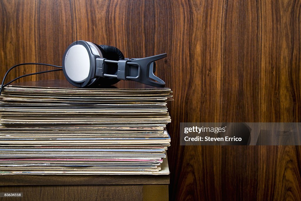 Headphones laying on stack of vinyl records