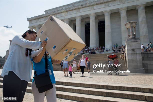 Two women use a viewing box to watch the solar eclipse at the Lincoln Memorial on August 21, 2017 in Washington, DC. Millions of people have flocked...