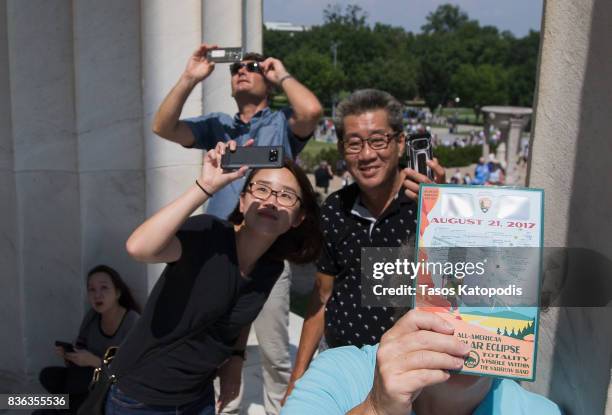 People gather at the Lincoln Memorial to watch the solar eclipse on August 21, 2017 in Washington, DC. Millions of people have flocked to areas of...