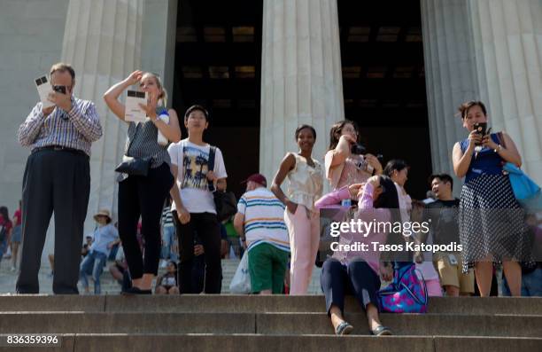 People gather at the Lincoln Memorial to watch the solar eclipse on August 21, 2017 in Washington, DC. Millions of people have flocked to areas of...