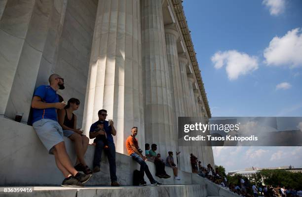 People gather at the Lincoln Memorial to watch the solar eclipse on August 21, 2017 in Washington, DC. Millions of people have flocked to areas of...