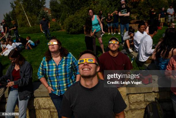 Students and onlookers look toward the sun with eclipse glasses on the campus of Montana State University on August 21, 2017 in Bozeman, Montana.