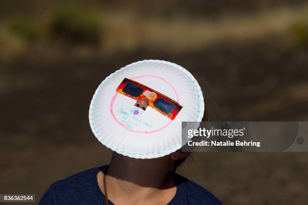 Girl uses bespoke eclipse glasses to watch the eclipse on Menan Butte August 21, 2017 in Menan, Idaho. Millions of people have flocked to areas of...
