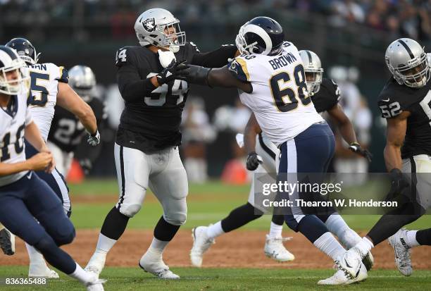 Eddie Vanderdoes of the Oakland Raiders rushes up against Jamon Brown of the Los Angeles Rams during the first quarter of their preseason NFL...