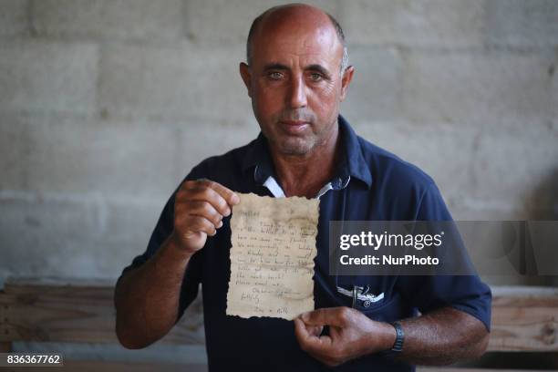 Palestinian fisherman Jihad al-Soltan displays a message that was written by Bethany Wright and her boyfriend Zac Marriner, after he found it in a...