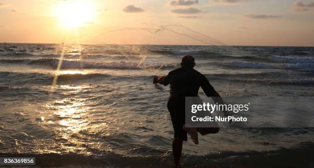 Palestinian fisherman Jihad al-Soltan prepares his fishing net on a beach in the northern Gaza Strip August 21, 2017.