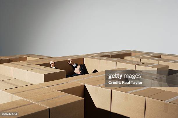 boxes forming maze with man - box trap stock pictures, royalty-free photos & images