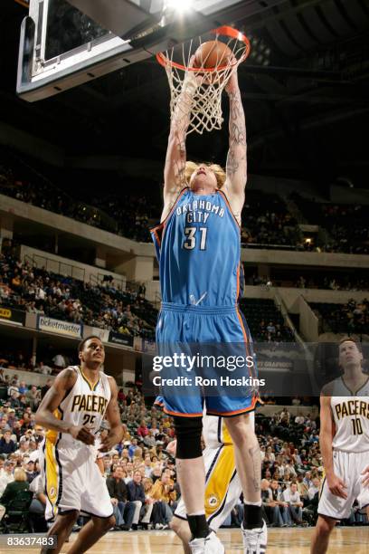 Robert Swift the Oklahoma City Thunder drives past Brandon Rush and Jeff Foster of the Indiana Pacers at Conseco Fieldhouse on November 10, 2008 in...