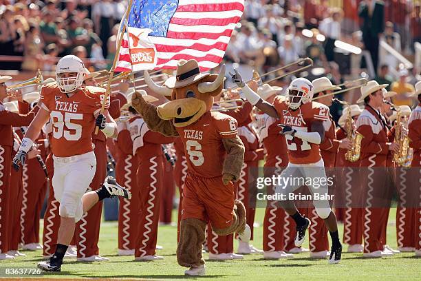 Aaron Lewis of the Texas Longhorns carries the American flag as he leads his team onto the field before the game against the Baylor Bears on November...