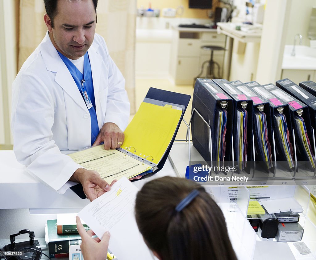 Doctor & nurse reviewing patient chart in recovery