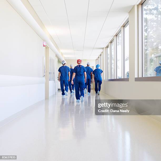 surgical team walking down hospital corridor       - corridor bildbanksfoton och bilder