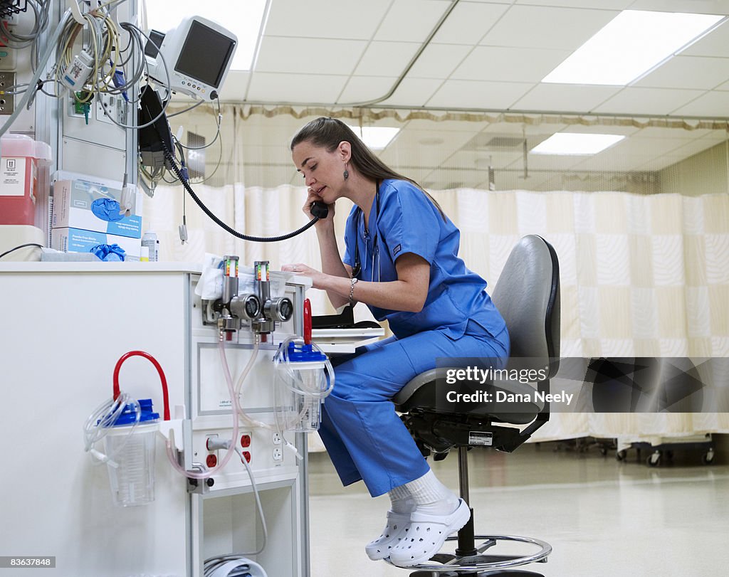 Female nurse on phone in PACU of hospital 