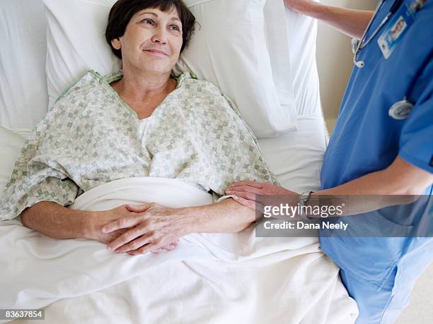 nurse comforting senior female patient       - sick patient stock pictures, royalty-free photos & images