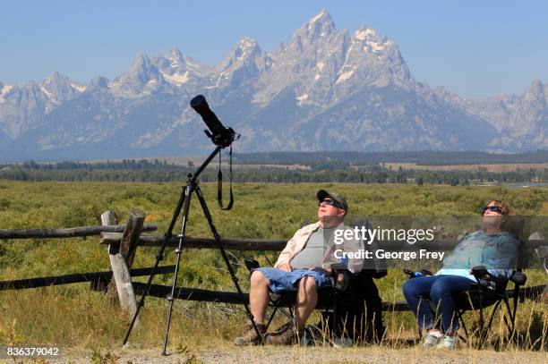 Couple woman views the solar eclipse in the first phase of a total eclipse in Grand Teton National Park on August 21, 2017 outside Jackson, Wyoming....