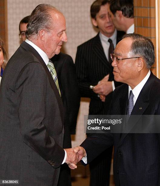 King Juan Carlos of Spain shakes hands with Japan Business Federation, or Keidanren, Chairman Fujio Mitarai upon arriving for a breakfast with...