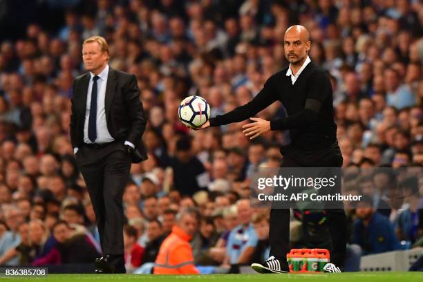 Manchester City's Spanish manager Pep Guardiola and Everton's Dutch manager Ronald Koeman gesture during the English Premier League football match...