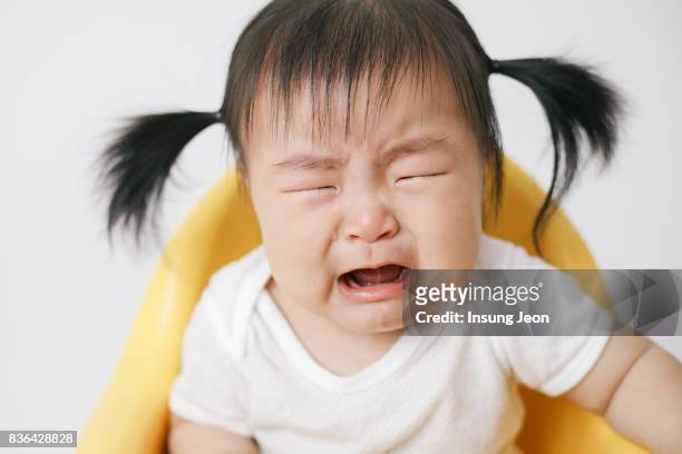 mother feeding baby girl with spoon - korean baby girl stock-fotos und bilder
