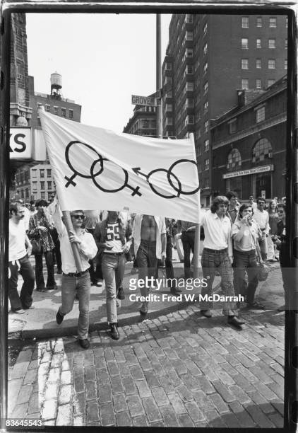 One month after the demonstrations and conflict at the Stonewall Inn, a group of approximately 200 people march along West 4th Street in the first...