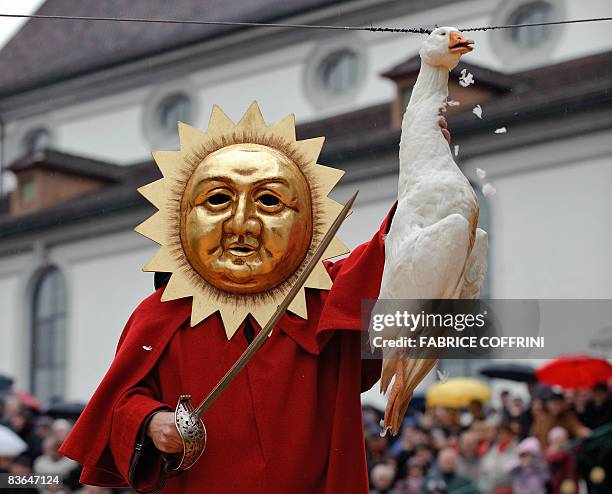 Man tries to cut off the head of a dead goose with a blunt sabre during the "Gansabhauet" event, an ancient custom that takes place every year on the...