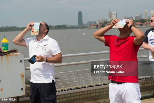 People watch the solar eclipse at Liberty Island on August 21, 2017 in New York City. While New York was not in the path of totality for the solar...
