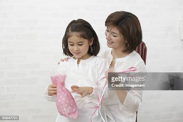 mother and daughter opening gift - woman smiling facing down stock pictures, royalty-free photos & images
