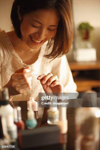 a woman painting her nails - woman smiling facing down stock pictures, royalty-free photos & images