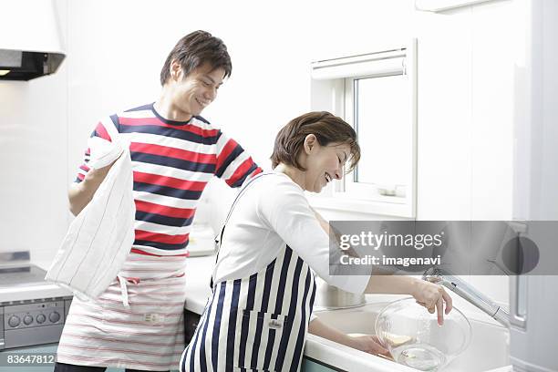 husband and wife washing dishes - striped kitchen towel stock pictures, royalty-free photos & images
