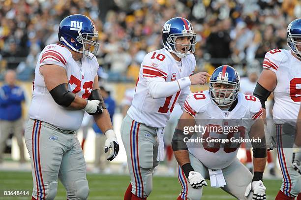 Quarterback Eli Manning of the New York Giants signals as offensive linemen Shaun O'Hara and Chris Snee look on during a game against the Pittsburgh...