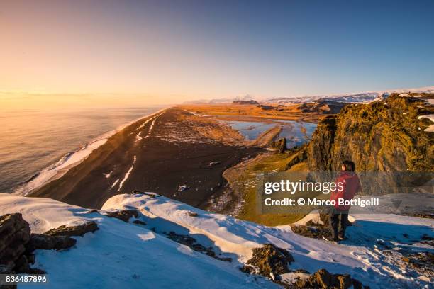 tourist at dyrholaey. vik i myrdal, iceland. - red coat stock pictures, royalty-free photos & images