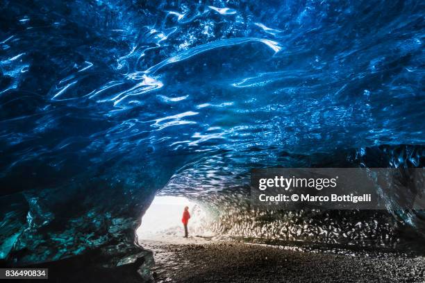 tourist in an ice cave. iceland. - vatnajokull photos et images de collection