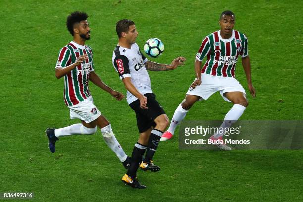 Renato Chaves and Marlon Freitas of Fluminense struggle for the ball with Rafael Moura of Atletico MG during a match between Fluminense and Atletico...