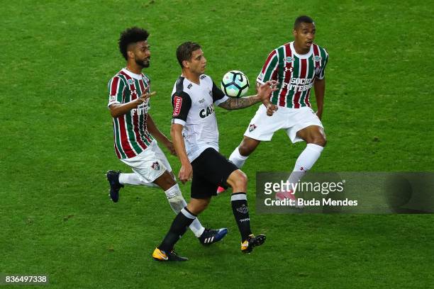 Renato Chaves and Marlon Freitas of Fluminense struggle for the ball with Rafael Moura of Atletico MG during a match between Fluminense and Atletico...