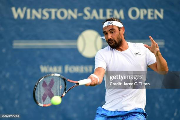 Marcos Baghdatis of Cyprus returns a shot from Jiri Vesely of Czech Republic during the third day of the Winston-Salem Open at Wake Forest University...