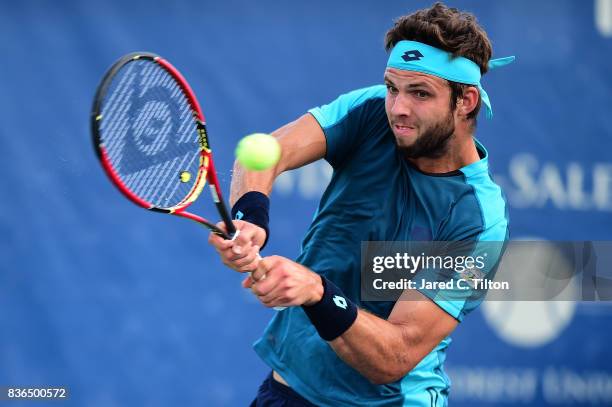 Jiri Vesely of Czech Republic returns a shot from Marcos Baghdatis of Cyprus during the third day of the Winston-Salem Open at Wake Forest University...