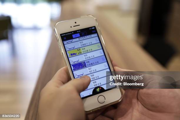 Nursing care worker looks at the residents' sleeping conditions on the "EGAO link" system on an Apple Inc. IPhone in an arranged photograph at the As...