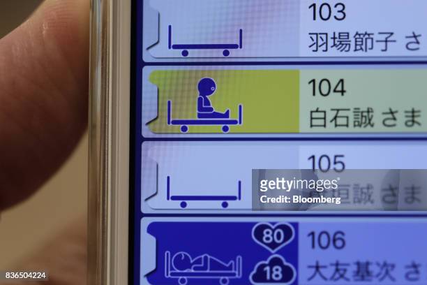 An icon showing a resident is seated up on a bed is displayed on the "EGAO link" system on an Apple Inc. IPhone in an arranged photograph at the As...